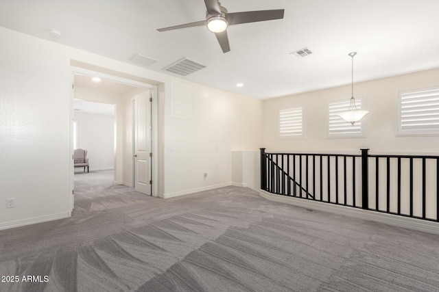 unfurnished room with a ceiling fan, baseboards, visible vents, and carpet