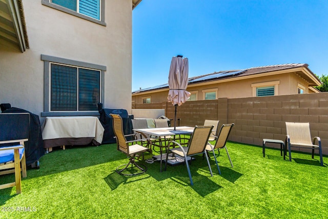 view of yard with fence and outdoor dining space