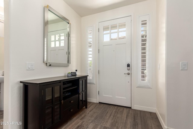 entryway with baseboards and dark wood-type flooring