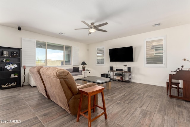 living room featuring ceiling fan, baseboards, visible vents, and wood finished floors
