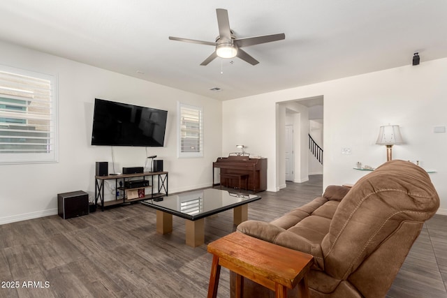 living area with baseboards, visible vents, ceiling fan, stairs, and wood finished floors