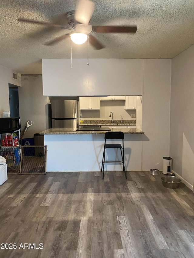 3229 W Cholla St, Phoenix, AZ 85029 - kitchen with freestanding refrigerator, a ceiling fan, white cabinetry, a textured ceiling, and dark wood-style flooring