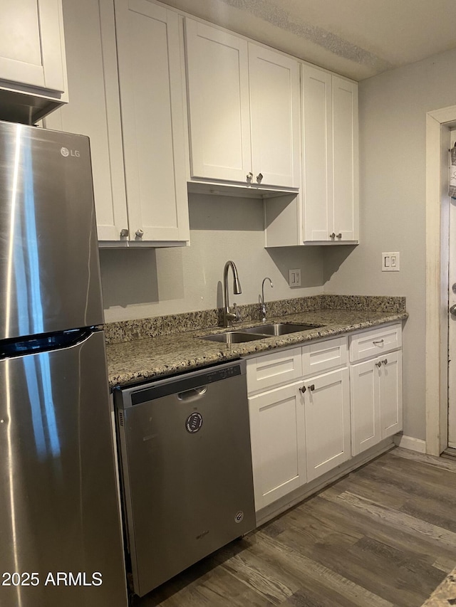 3229 W Cholla St, Phoenix, AZ 85029 - kitchen featuring appliances with stainless steel finishes, a sink, white cabinets, dark wood-type flooring, and light stone countertops