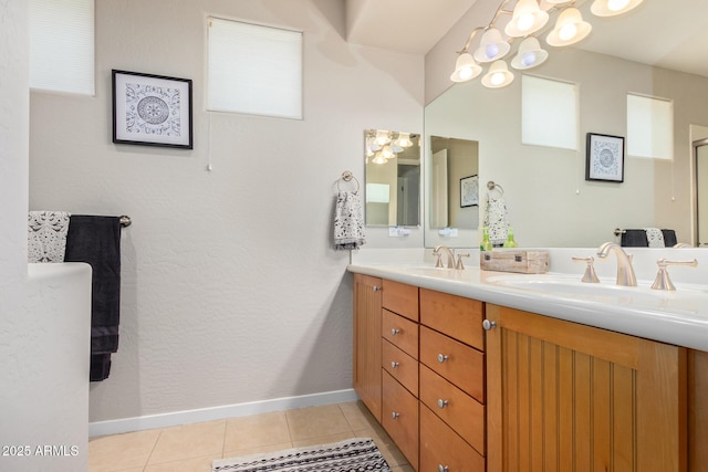 bathroom featuring tile patterned floors, baseboards, double vanity, and a sink