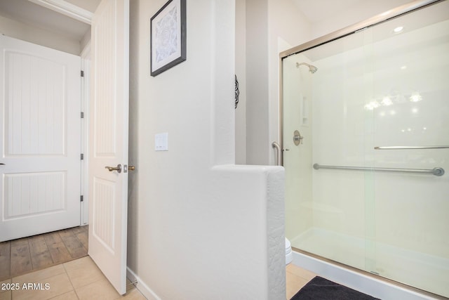 full bath featuring tile patterned floors and a stall shower