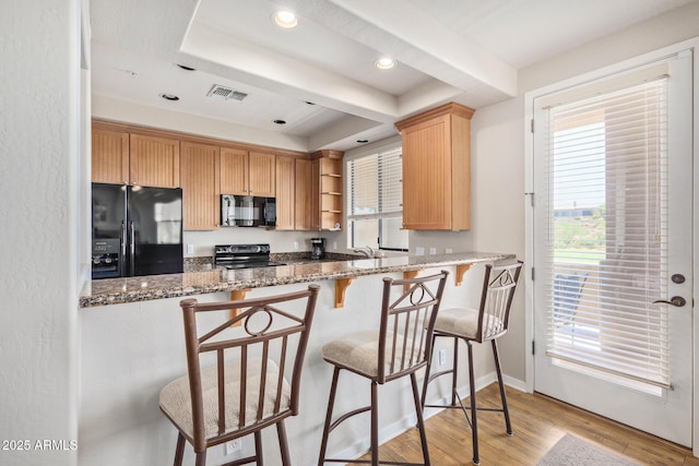 kitchen featuring light stone countertops, visible vents, open shelves, black appliances, and light wood-type flooring