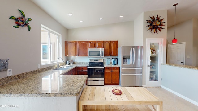 kitchen featuring light stone counters, recessed lighting, a sink, appliances with stainless steel finishes, and brown cabinetry