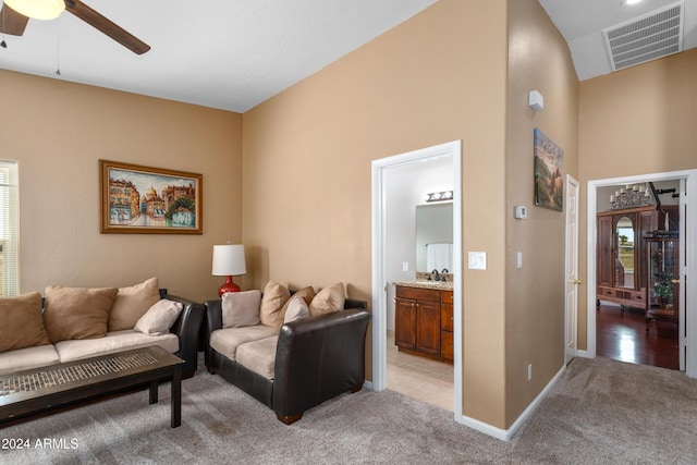 living area featuring ceiling fan, visible vents, baseboards, and light colored carpet