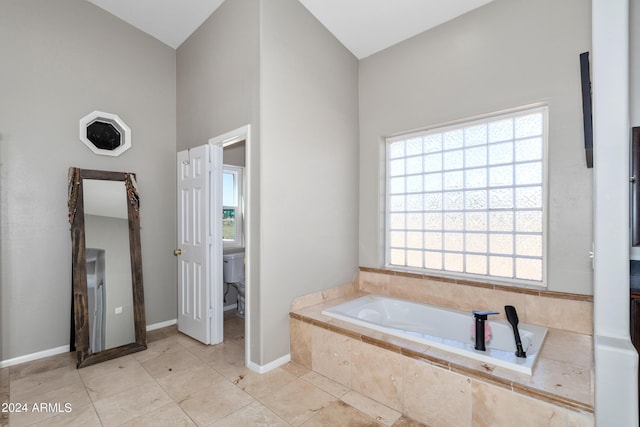 bathroom with tile patterned flooring, a garden tub, and baseboards