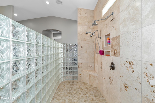bathroom featuring vaulted ceiling, walk in shower, and visible vents