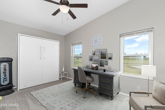 office area featuring lofted ceiling, baseboards, a ceiling fan, and light colored carpet