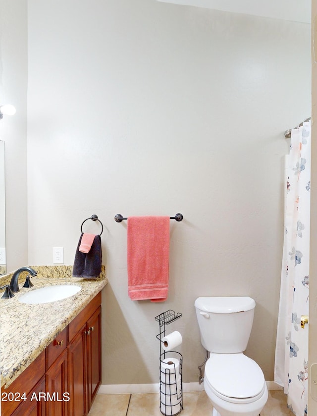 bathroom featuring toilet, baseboards, vanity, and tile patterned floors
