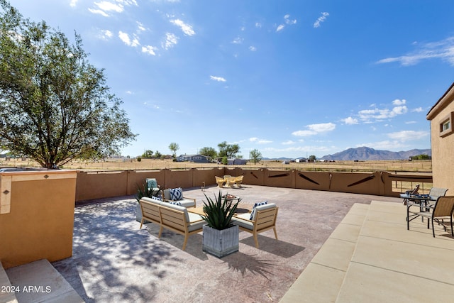 view of patio with fence and a mountain view