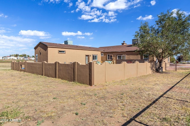 rear view of property with fence and stucco siding