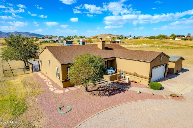 view of front of home featuring concrete driveway, a gate, fence, a mountain view, and stucco siding