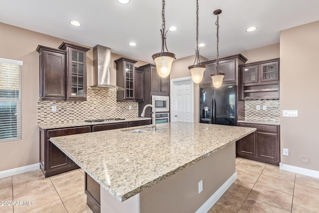 kitchen with a center island with sink, sink, wall chimney range hood, and stainless steel appliances