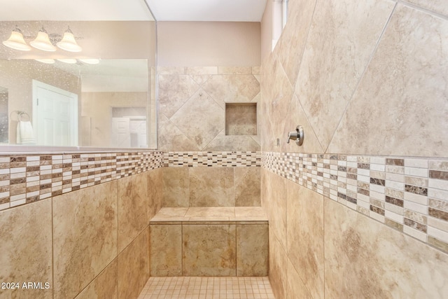 bathroom featuring tile patterned floors, tile walls, and tiled shower