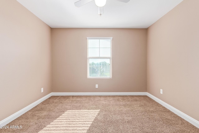 carpeted spare room with ceiling fan