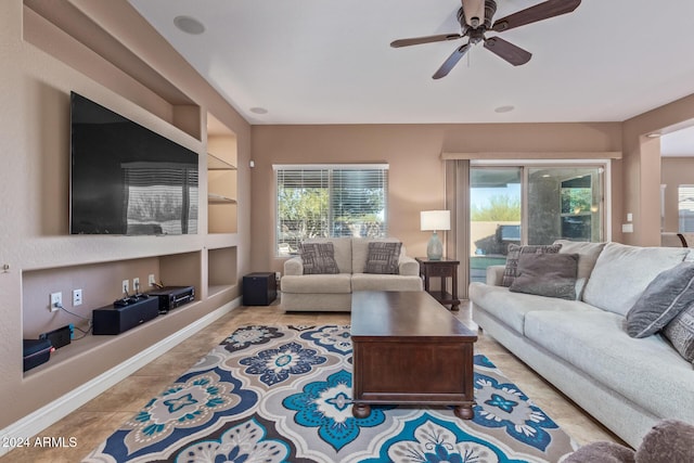 living room featuring built in features, ceiling fan, and light tile patterned flooring