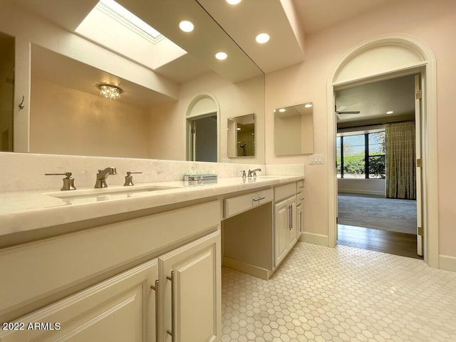 bathroom featuring vanity, a skylight, and tasteful backsplash