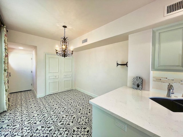 interior space featuring sink, a notable chandelier, and decorative backsplash