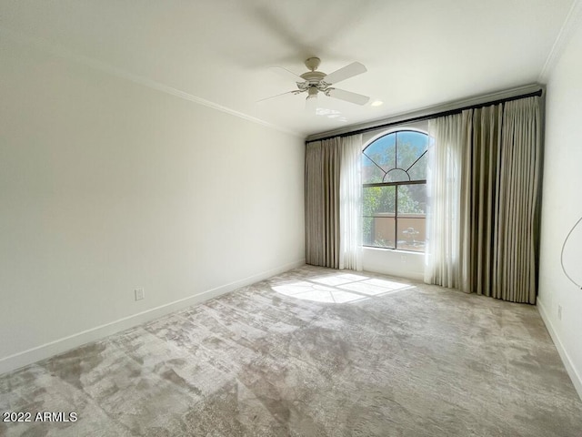 spare room featuring crown molding, light colored carpet, and ceiling fan