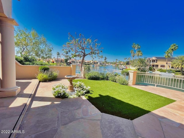 view of yard with a water view and a patio area