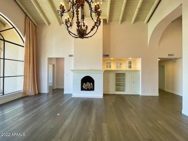 unfurnished living room with a notable chandelier, dark hardwood / wood-style flooring, beam ceiling, and wooden ceiling