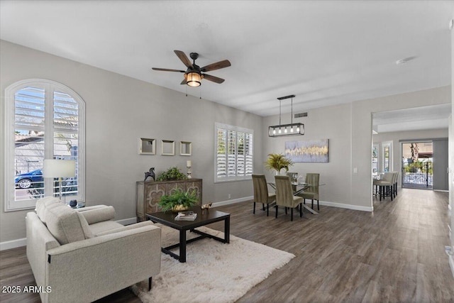 living area featuring a wealth of natural light, visible vents, and wood finished floors