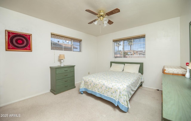 bedroom with ceiling fan, baseboards, and light carpet