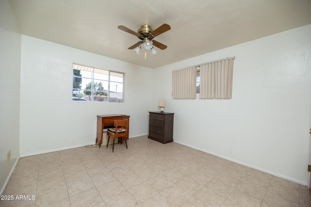 unfurnished room featuring light tile patterned floors, baseboards, and a ceiling fan