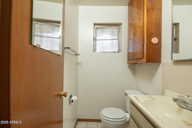 half bathroom featuring backsplash, toilet, vanity, and tile patterned floors