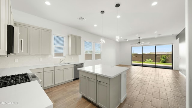 kitchen with stainless steel appliances, a sink, visible vents, open floor plan, and tasteful backsplash