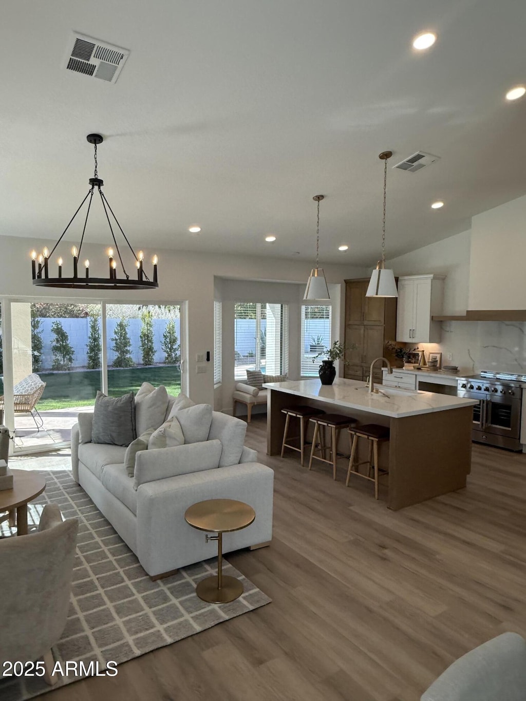 living room featuring sink, vaulted ceiling, and dark wood-type flooring