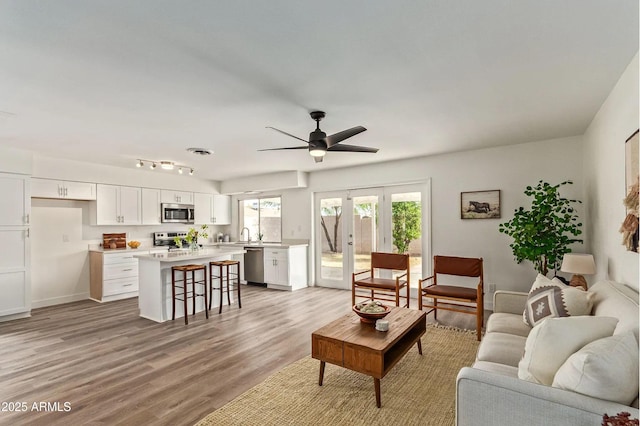 living room featuring light hardwood / wood-style flooring and ceiling fan