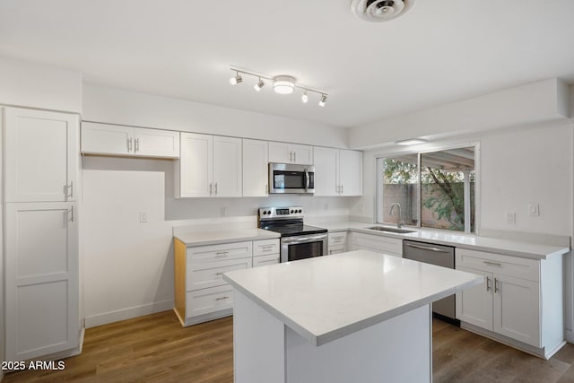 kitchen with stainless steel appliances, sink, white cabinets, and dark hardwood / wood-style flooring