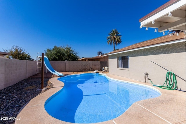 view of swimming pool featuring a water slide and a diving board