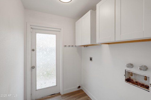 laundry area with cabinets, hookup for a washing machine, hookup for an electric dryer, and light wood-type flooring