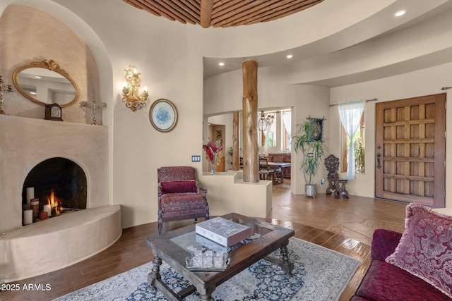 living room featuring recessed lighting, a high ceiling, wood finished floors, and a fireplace