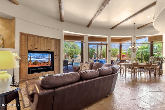 living room with beam ceiling, stone finish flooring, and a chandelier