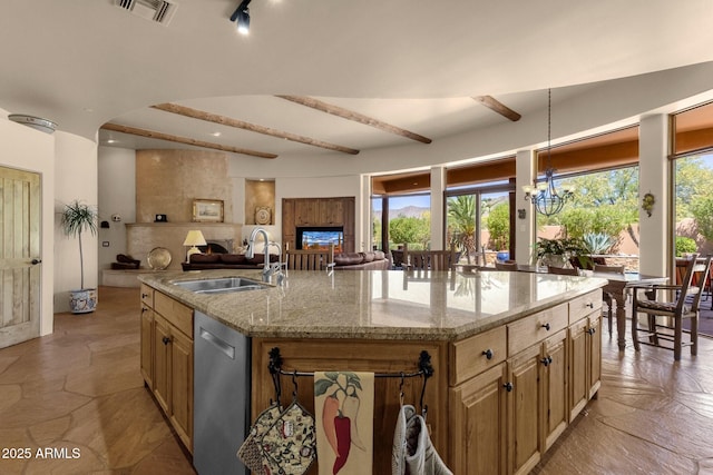 kitchen featuring light stone counters, a sink, visible vents, open floor plan, and dishwasher