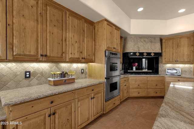 kitchen with light tile patterned floors, gas cooktop, stainless steel double oven, light stone countertops, and backsplash