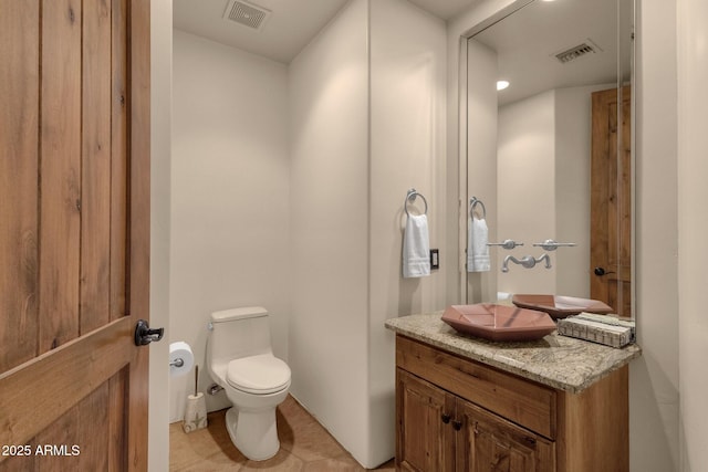 bathroom featuring tile patterned floors, visible vents, toilet, and vanity