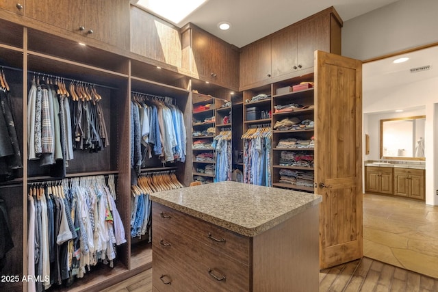 spacious closet featuring visible vents, light wood-style flooring, and a sink