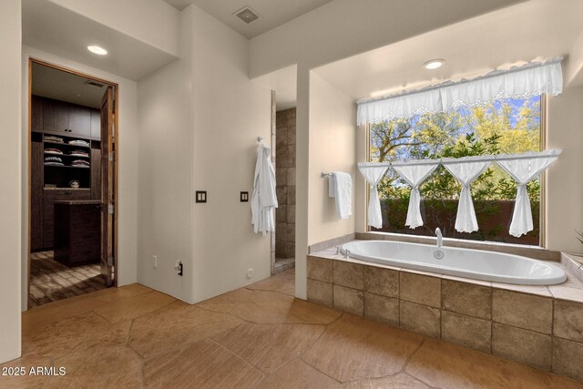 full bath with a garden tub and visible vents