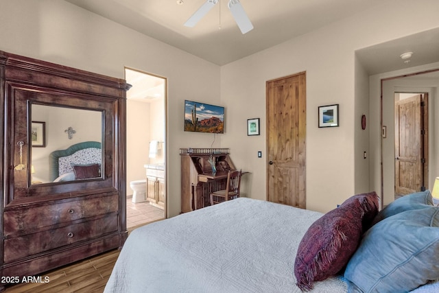 bedroom with wood finished floors, a ceiling fan, and ensuite bath