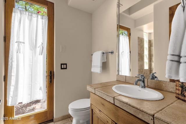 bathroom with a wealth of natural light, toilet, and vanity