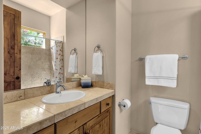 bathroom with toilet, vanity, and a shower with shower curtain