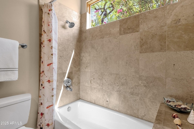 bathroom featuring toilet and shower / bath combination with curtain