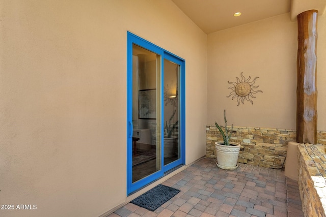 doorway to property featuring a patio and stucco siding